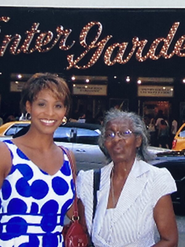Image of Julia and Nellie Yarbough standing in front of New York Broadway sign for Mama Mia